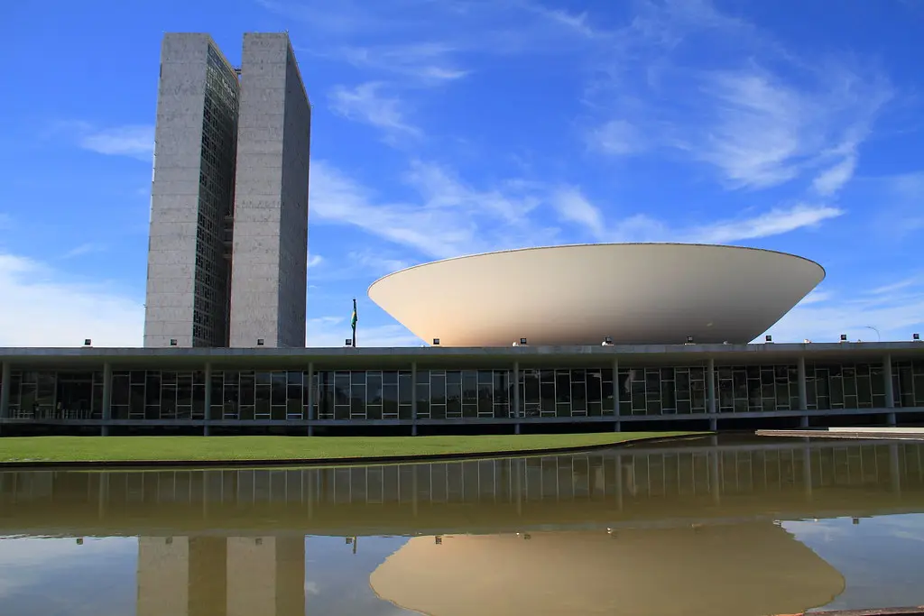 Das Gebäude des Nationalkongresses in Brasília mit seinen charakteristischen Türmen und Kuppeln am Wasser.