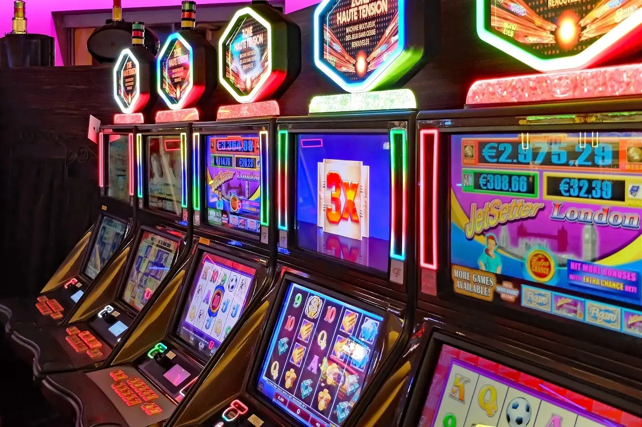 Eine Reihe von bunten, beleuchteten Spielautomaten in einem Casino.