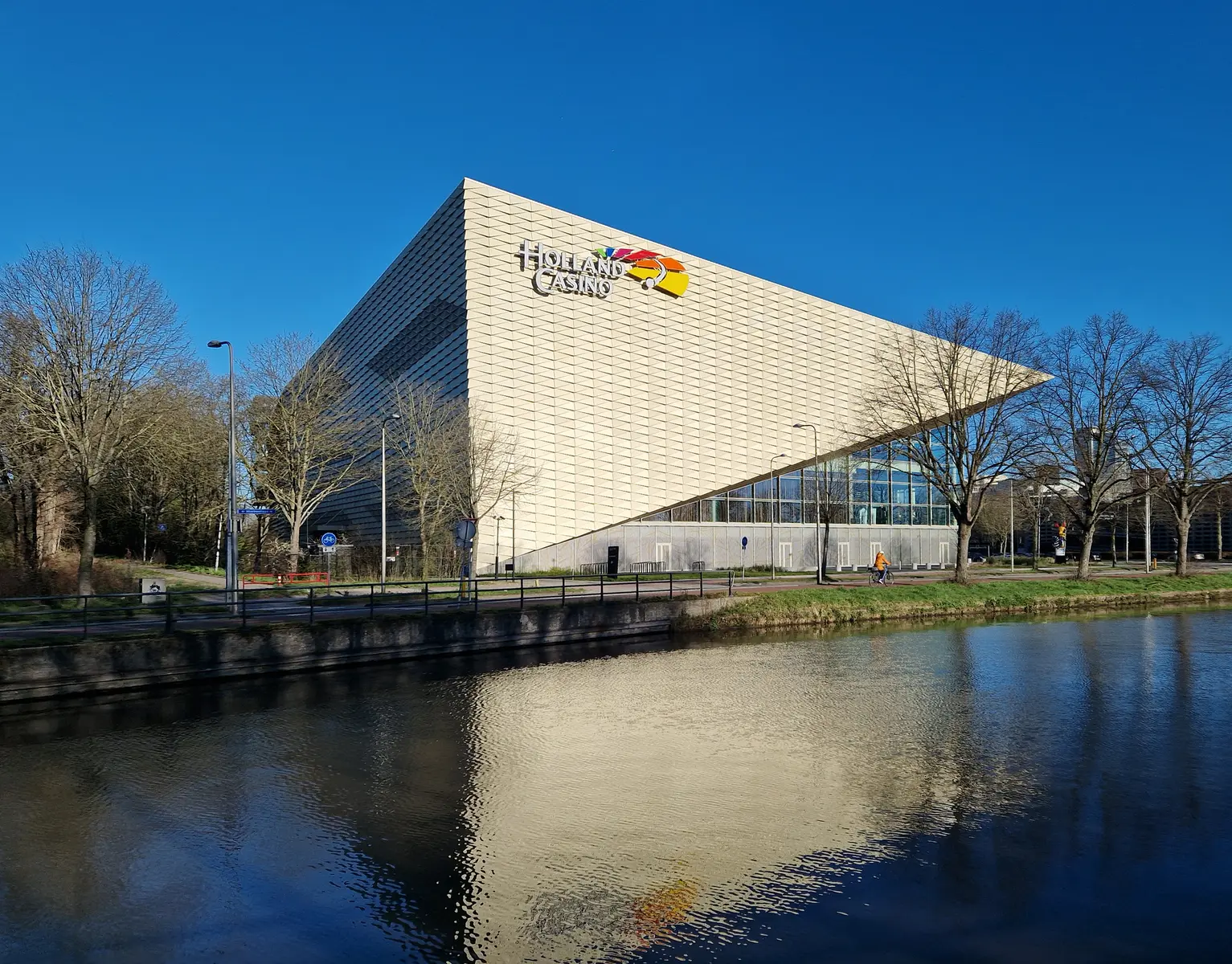 Het moderne gebouw van Holland Casino in Utrecht, weerspiegeld in het water.