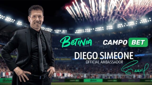 Diego Simeone poserar på en fotbollsarena med Betinia och CampoBet-logotyper i bakgrunden.