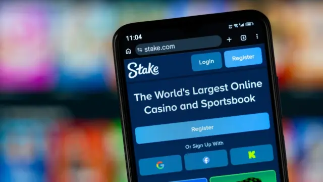 Stake visas på en mobilskärm med casino- och bettingplattformen öppen