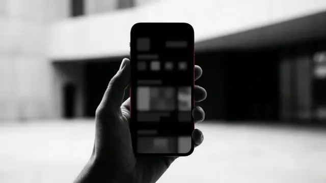 Smartphone i svartvitt ljus symboliserar granskningen av olagliga spelannonser på sociala medier