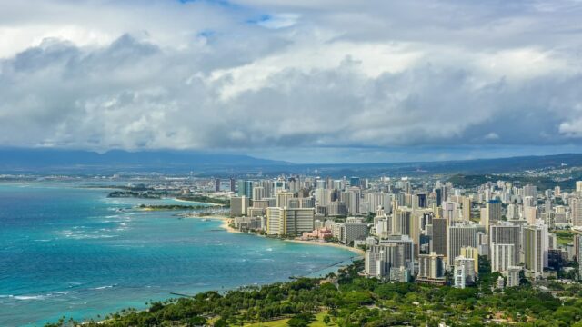 Aerial view of Honolulu skyline along the Waikiki coastline with high-rise buildings and the Pacific Ocean