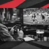 Sports fan using a mobile betting site while watching football