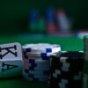Ace and king playing cards with stacked poker chips on a green table