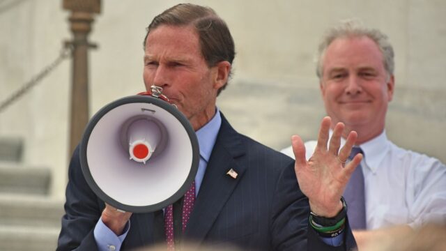 Senator Richard Blumenthal speaks into a megaphone.