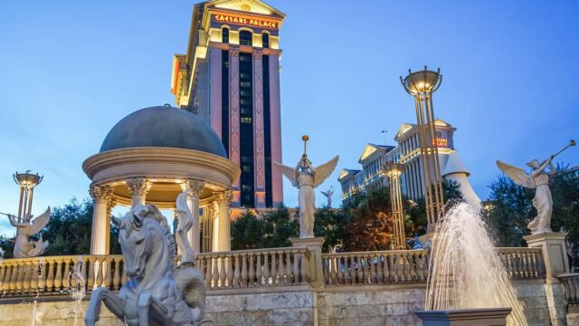 Exterior view of Caesars Palace hotel and casino in Las Vegas with fountains and Roman-style statues at dusk