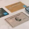 Multiple credit cards next to a smartphone displaying a digital card wallet