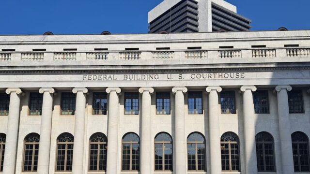 Exterior of a federal courthouse building with columns and “Federal Building U.S. Courthouse” signage