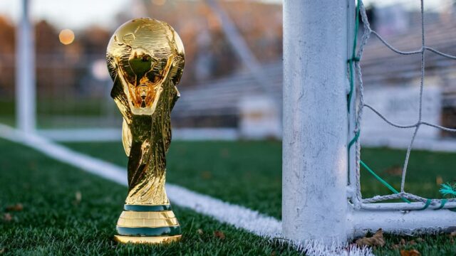 FIFA World Cup trophy positioned beside a soccer goal