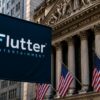 Flutter Entertainment banner displayed near the New York Stock Exchange building in New York City.