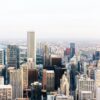 Aerial view of downtown Chicago featuring high-rise office buildings, residential towers and Lake Michigan in the background.