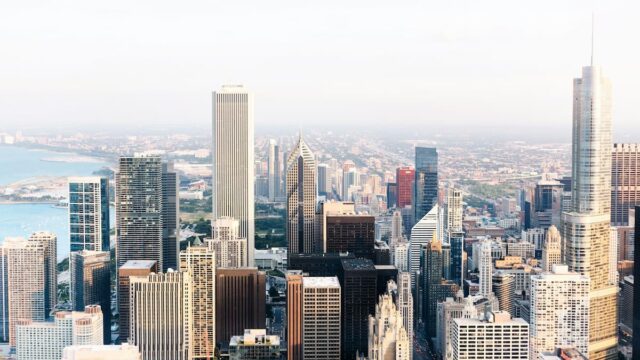 Aerial view of downtown Chicago featuring high-rise office buildings, residential towers and Lake Michigan in the background.