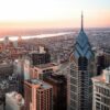 Aerial view of downtown Philadelphia, Pennsylvania, featuring the city's skyline and City Hall at sunset.