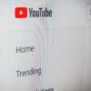 Close-up of the YouTube logo and navigation menu displayed on a computer screen.