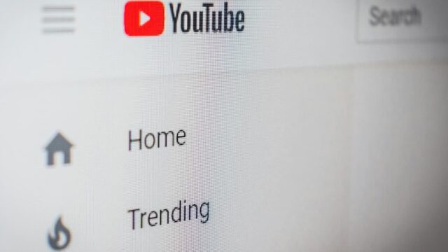 Close-up of the YouTube logo and navigation menu displayed on a computer screen.