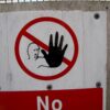 Red prohibition sign featuring a raised black hand