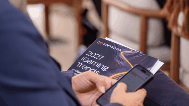 Attendee holds the SOFTSWISS 2027 iGaming Trends Report during its exclusive media launch ahead of SBC Summit.