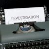 Typewriter with the word “Investigation” on a sheet of paper