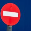 A red road sign with a white horizontal line.