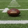 Wilson football resting on the yard lines of an American football field